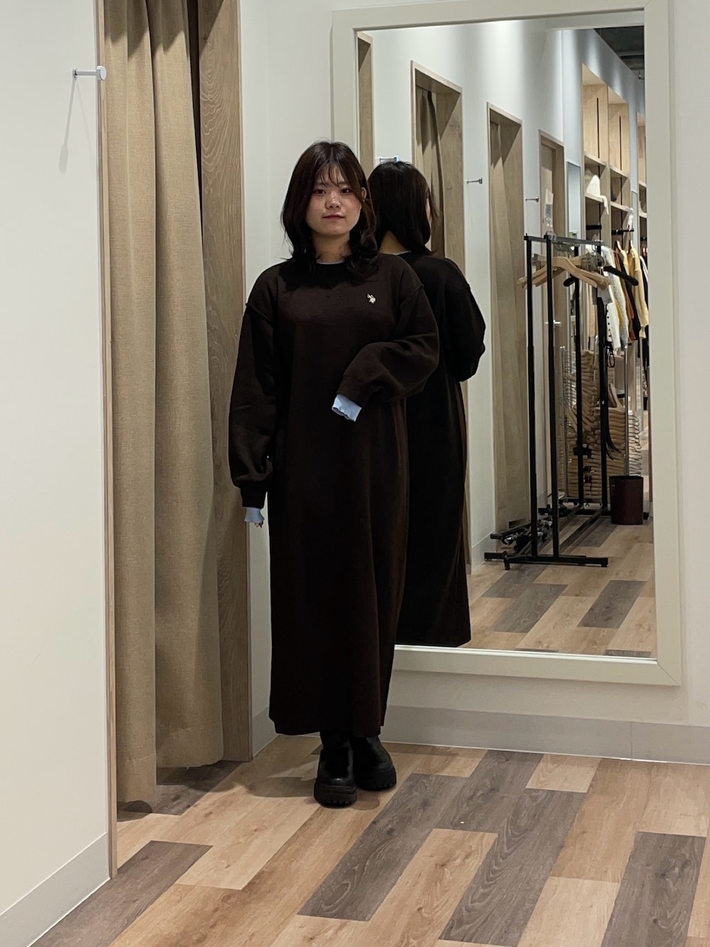 ブラウン系のワンピース、ブラック系のブーツを着用したレディースの秋コーディネートの1枚目の写真