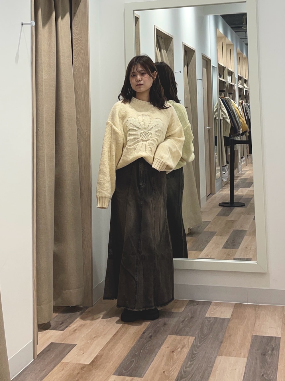 ブルー系のニット/セーター、ブルー系のスカートを着用したレディースの秋コーディネートの1枚目の写真