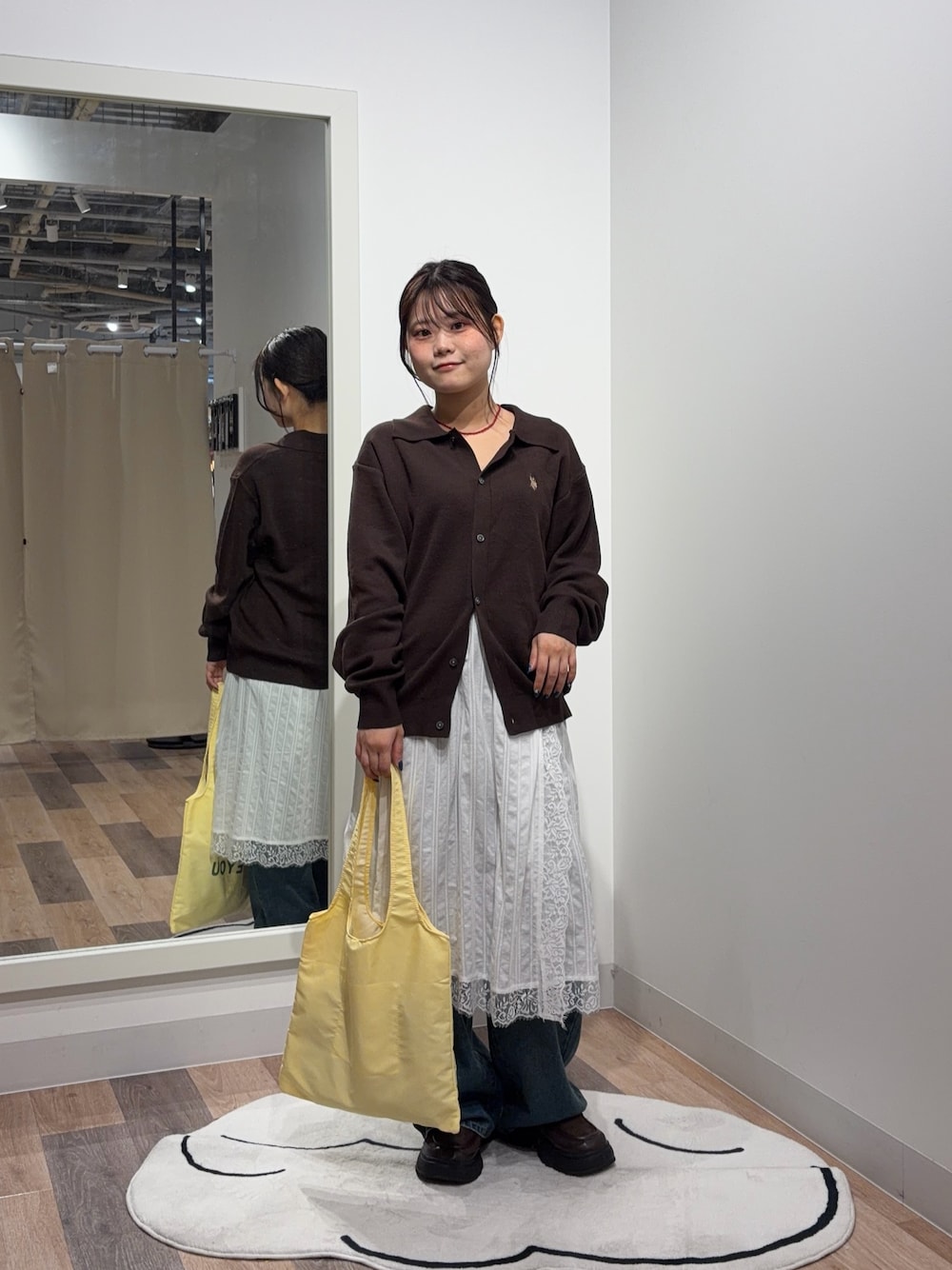 ブラウン系のカーディガン/ボレロ、ホワイト系のスカート、ブルー系のデニムパンツを着用したレディースの秋コーディネートの1枚目の写真