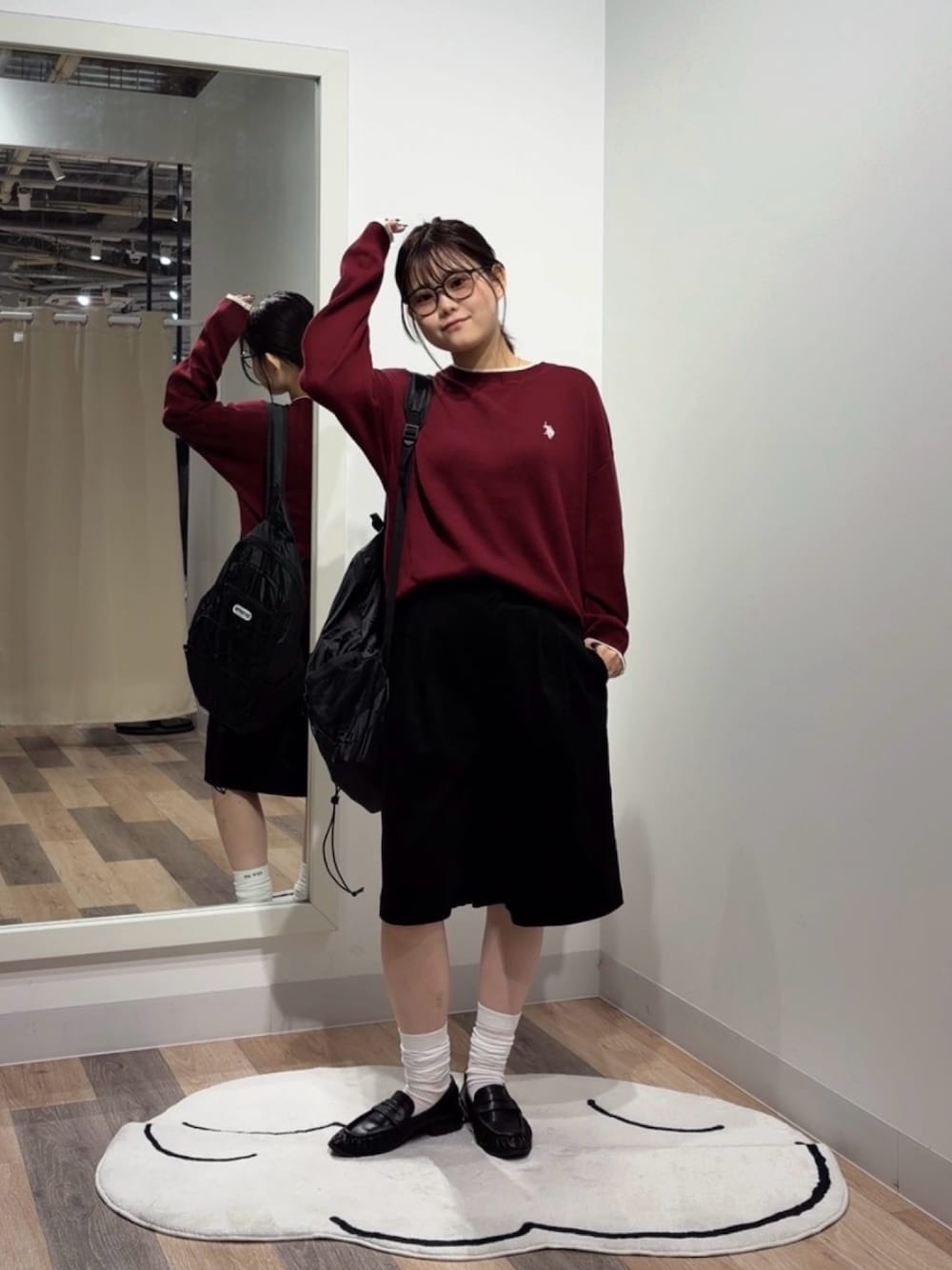 レッド系のニット/セーター、ブラック系のバックパック/リュック、ブラック系のその他シューズを着用したレディースの秋コーディネートの1枚目の写真