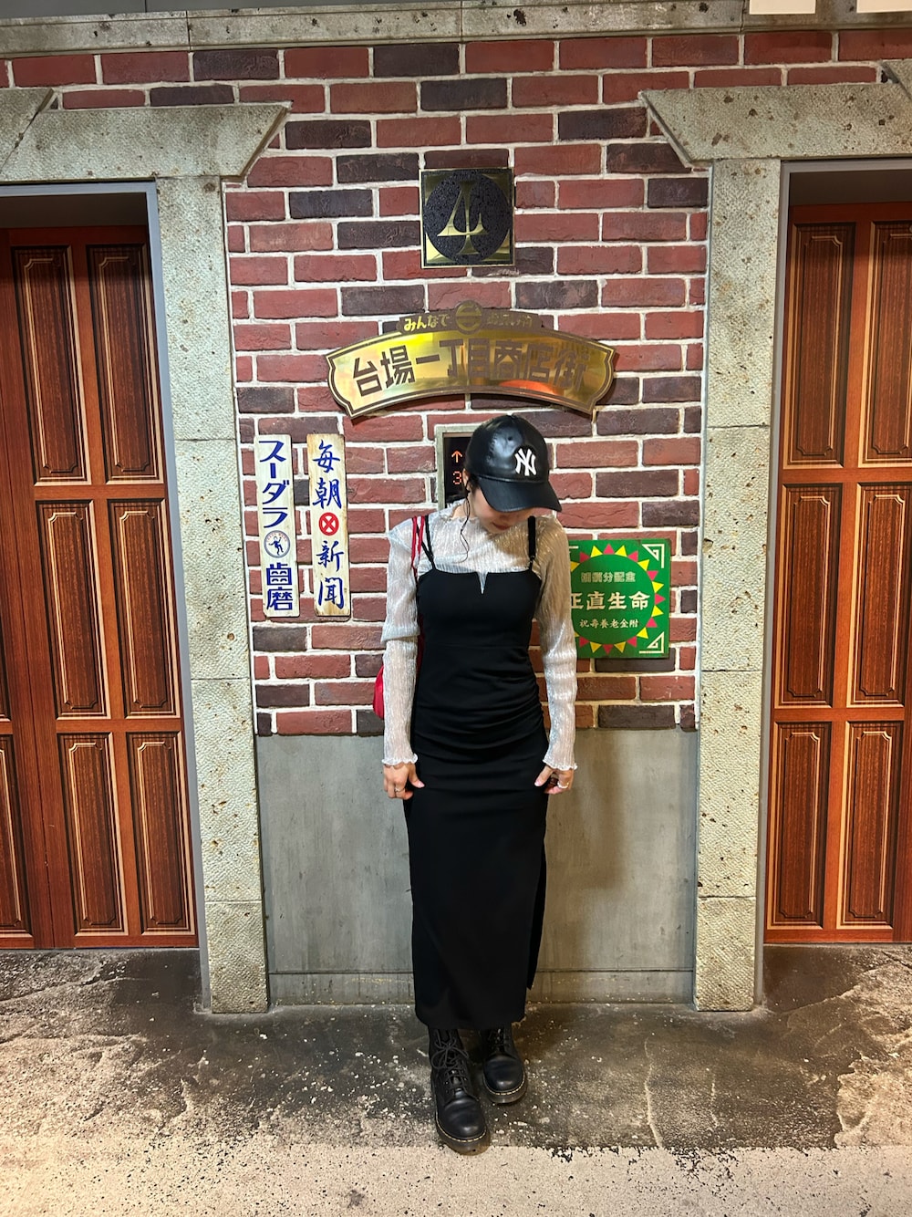 ブラック系のワンピース、ブラック系のブーツを着用したレディースの春コーディネートの1枚目の写真