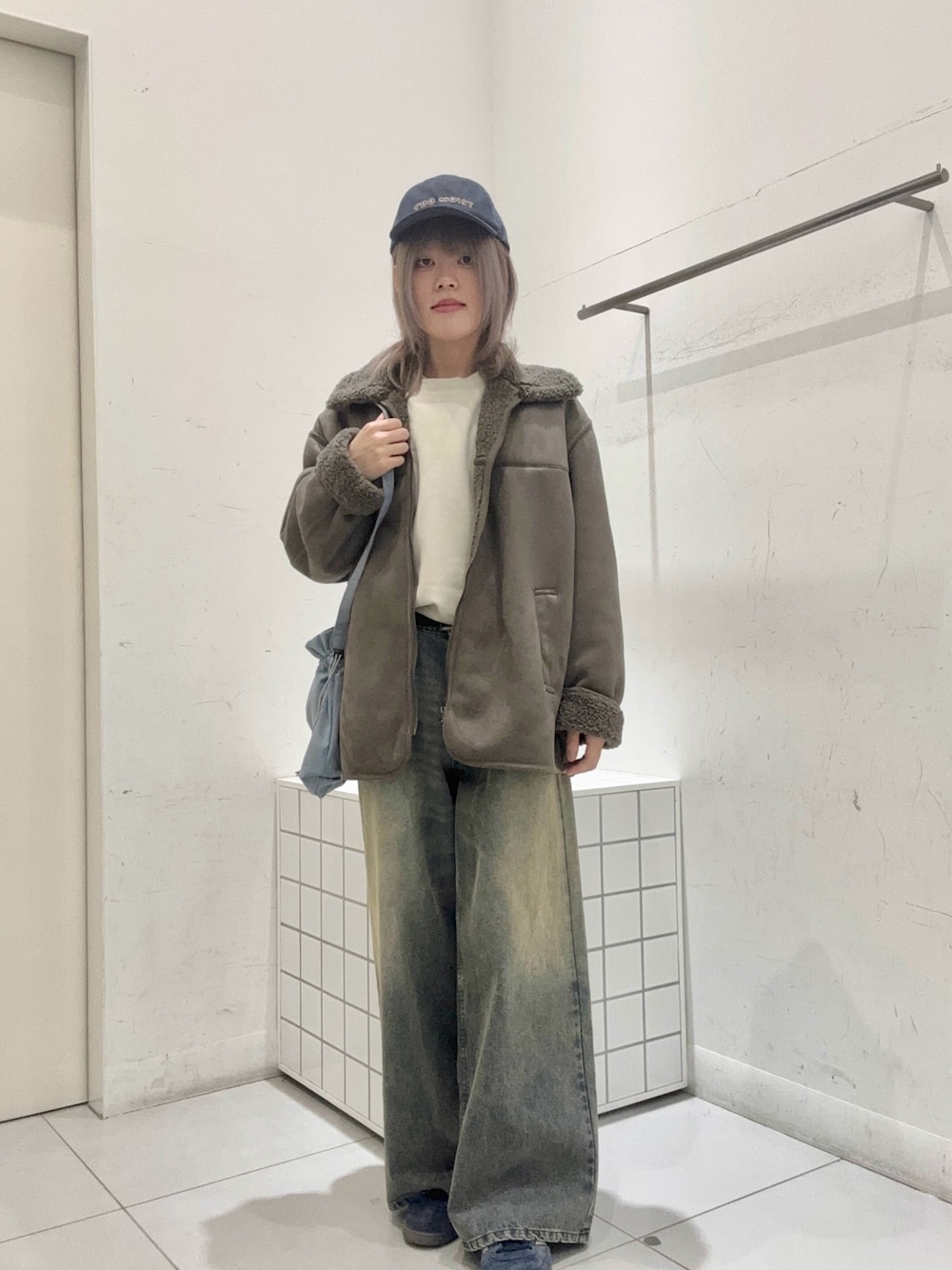 ベージュ系のスウェット、グレー系のブルゾン、ブルー系のショルダーバッグを着用したメンズの冬コーディネートの1枚目の写真