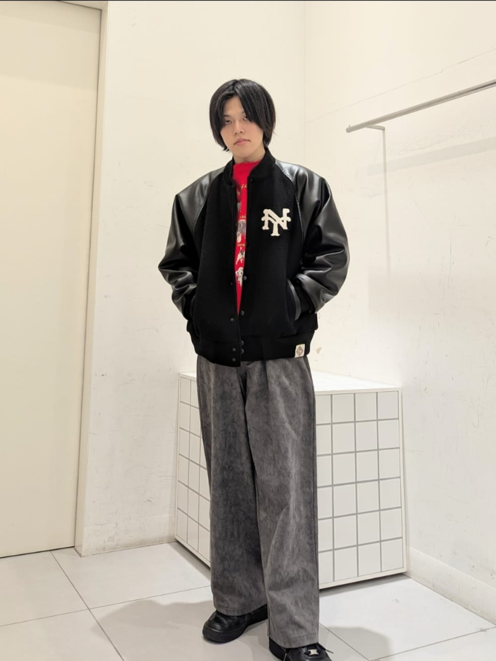 レッド系のスウェット、グレー系のその他パンツ、ブラック系のスタジャンを着用したメンズの冬コーディネートの1枚目の写真