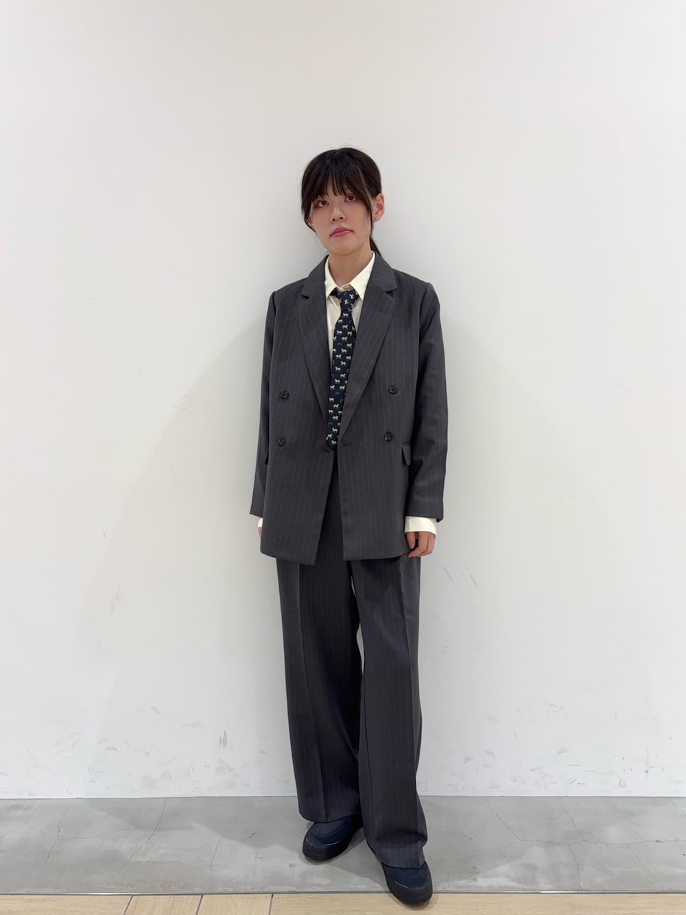 ブルー系のスニーカー、ホワイト系のシャツ/ブラウス、ブルー系のネクタイを着用したメンズの秋コーディネートの1枚目の写真