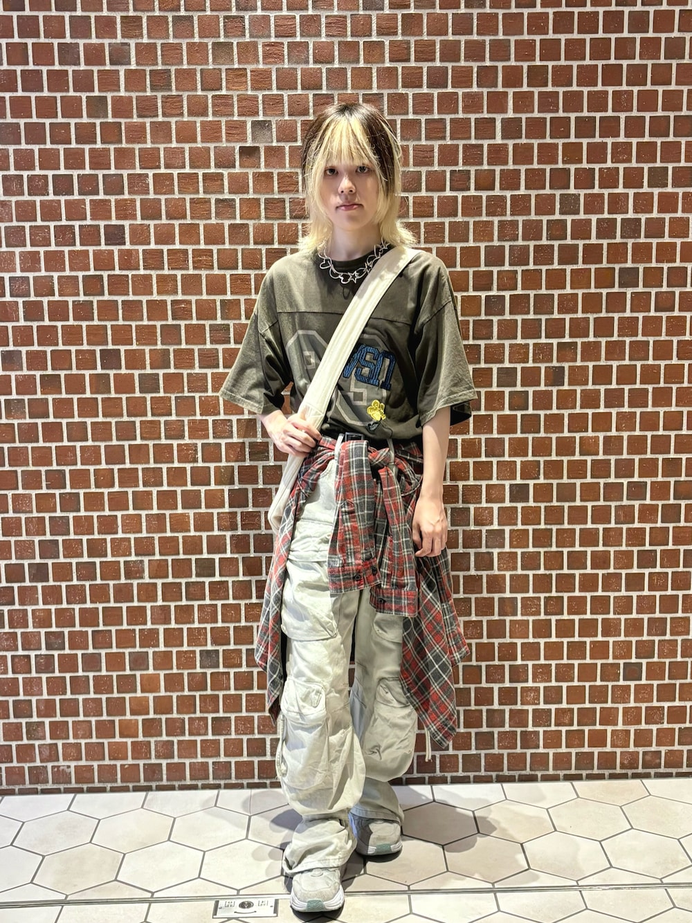 ホワイト系のショルダーバッグ、ブラウン系のトップス、ホワイト系のカーゴパンツを着用したメンズの夏コーディネートの1枚目の写真