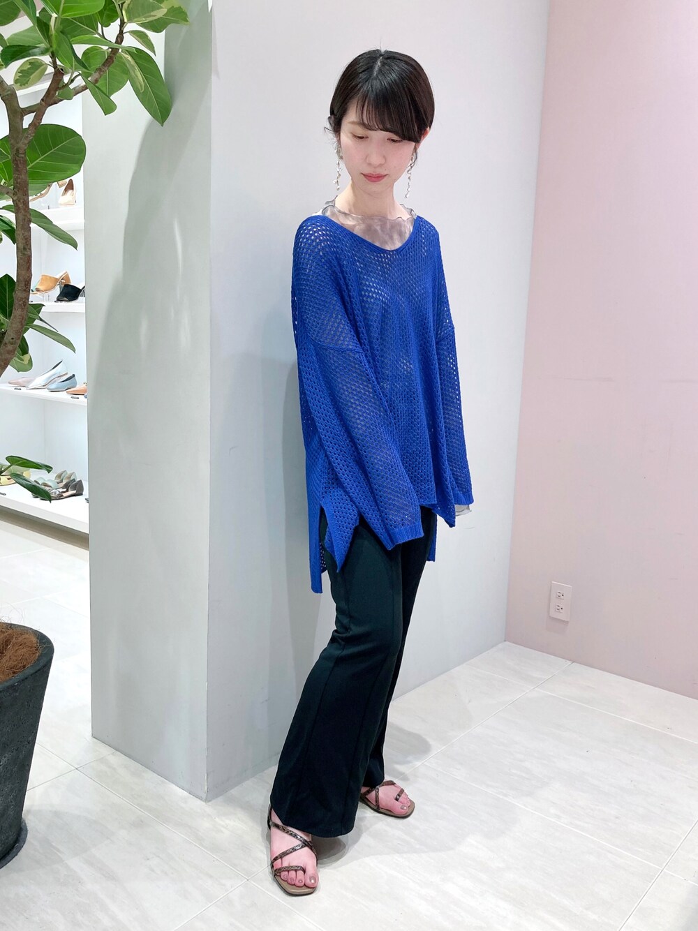 ブラック系のサンダル、ブルー系のニット/セーター、グレー系のTシャツ/カットソーを着用したレディースの春コーディネートの1枚目の写真