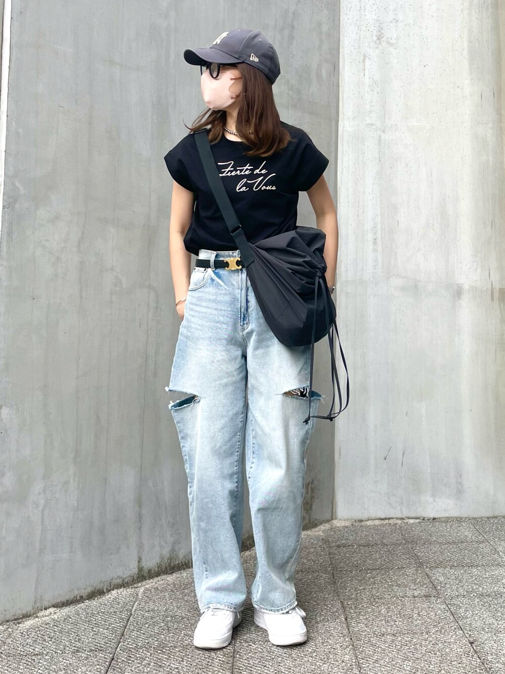 ブルー系のデニムパンツ、ブラック系のバッグ、ブラック系のTシャツ/カットソーを着用したレディースの春コーディネートの1枚目の写真