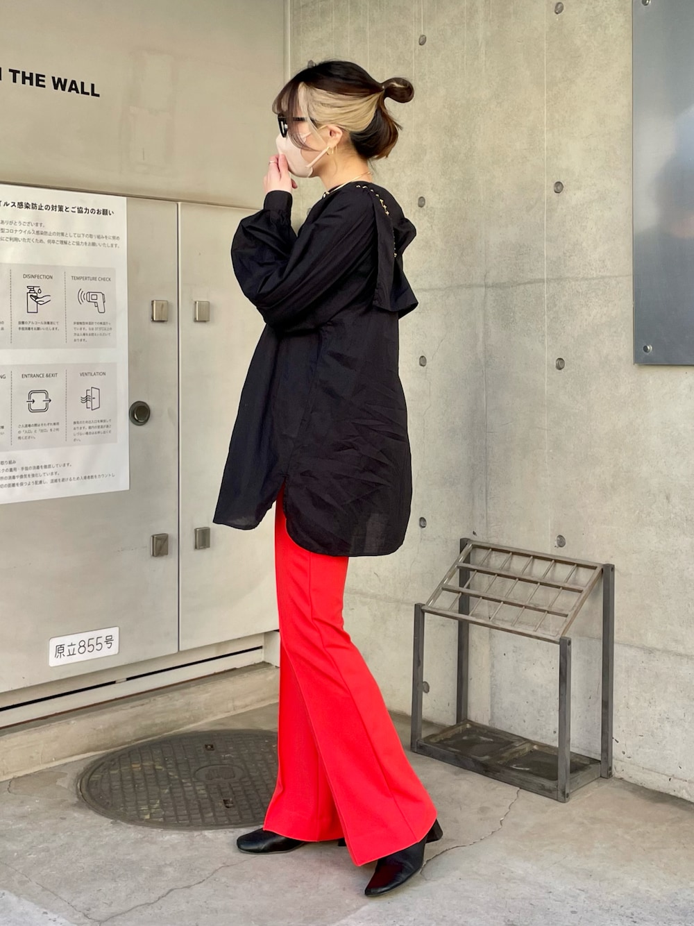 ブラック系のシャツ/ブラウス、オレンジ系のパンツを着用したレディースの春コーディネートの1枚目の写真