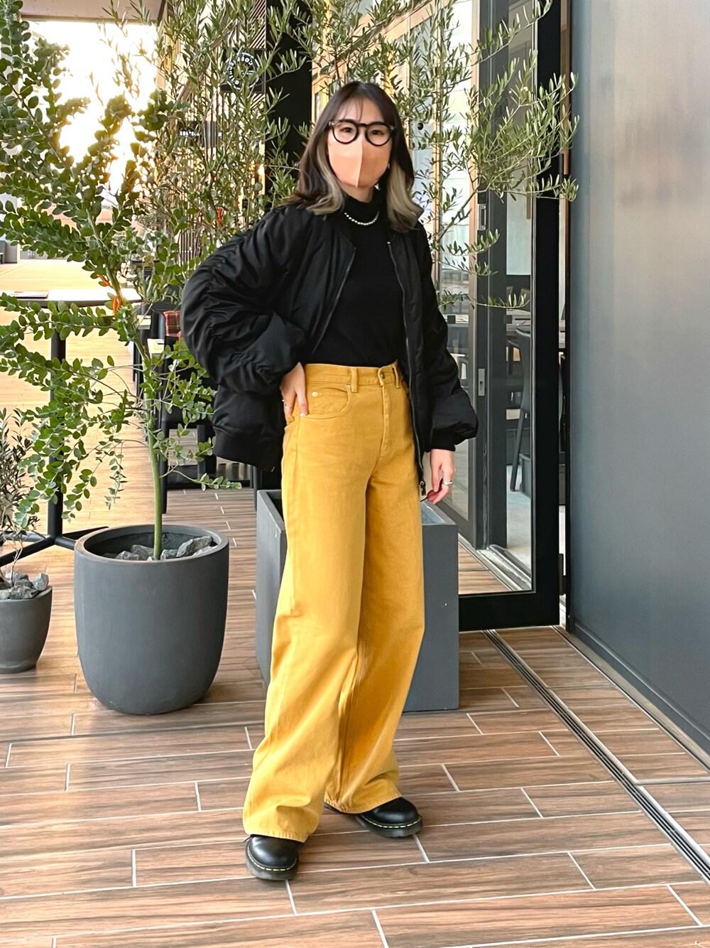 イエロー系のパンツ、ブラック系のMA-1、ブラック系のトップスを着用したレディースの春コーディネートの1枚目の写真