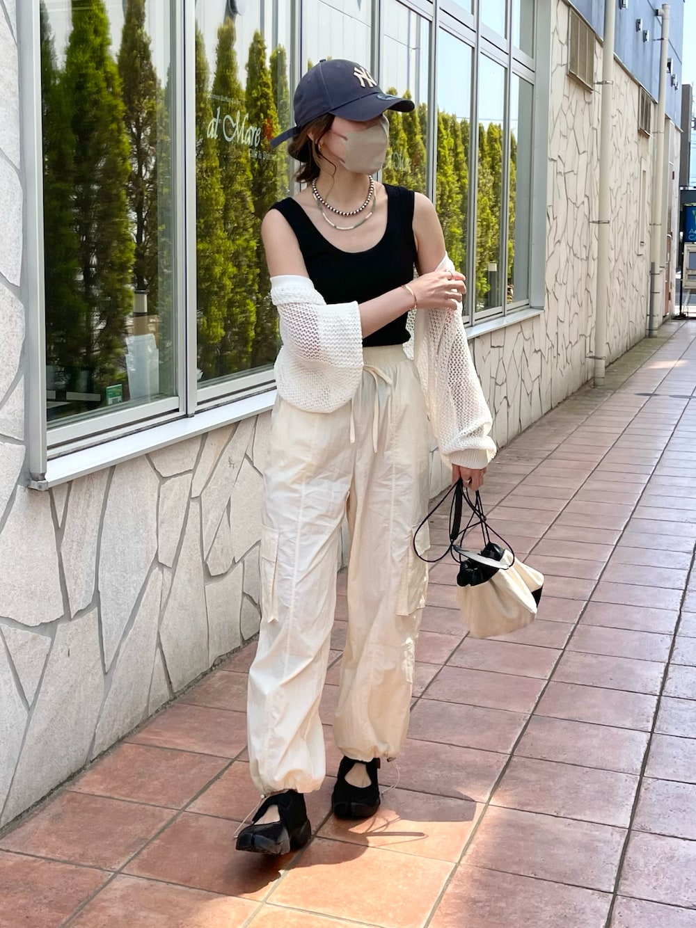 ブラック系のサンダル、ホワイト系のカーゴパンツ、ブラック系のタンクトップを着用したレディースの春コーディネートの1枚目の写真