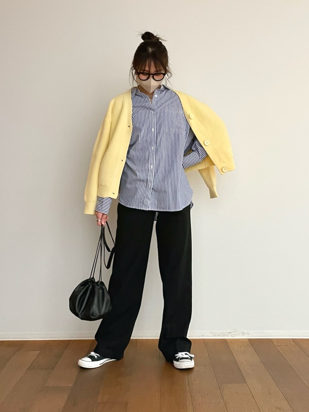 ブラック系のパンツ、ブルー系のシャツ/ブラウス、イエロー系のカーディガン/ボレロを着用したレディースの春コーディネートの1枚目の写真