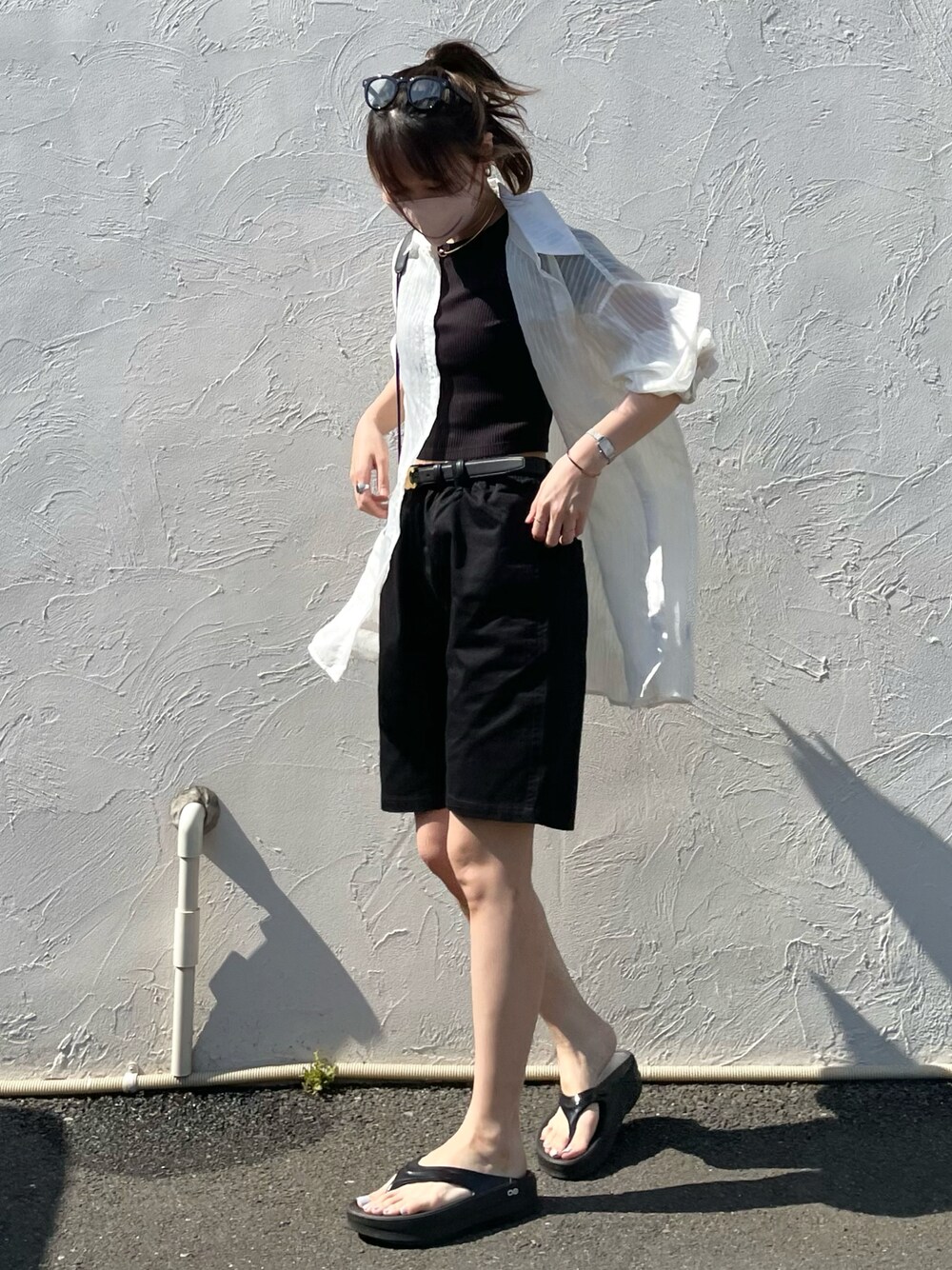 ブラック系のチノパンツ、ブラック系のサンダル、ブラック系のTシャツ/カットソーを着用したレディースの春コーディネートの1枚目の写真
