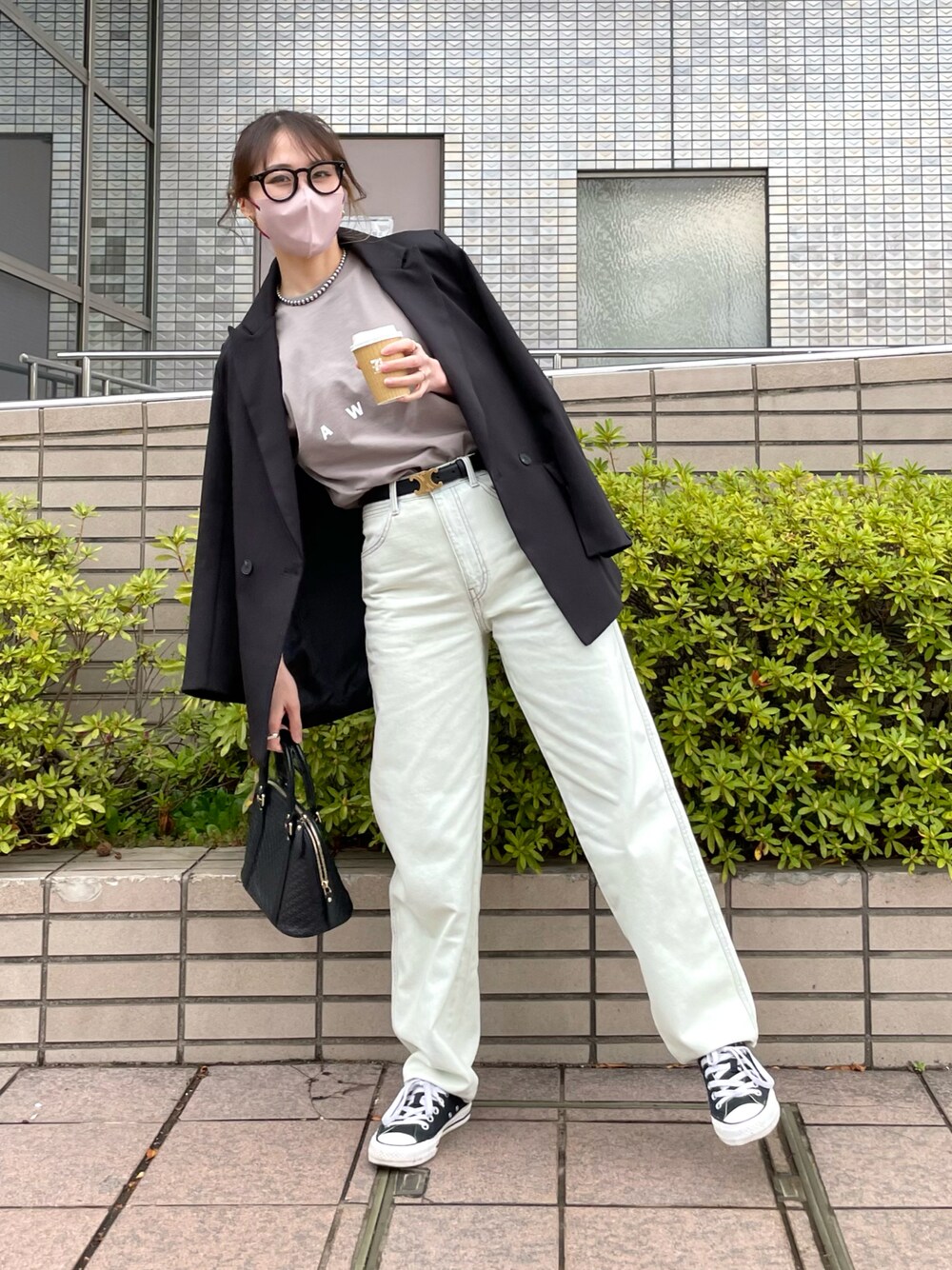 ブルー系のデニムパンツ、ベージュ系のTシャツ/カットソー、ブラック系のバッグを着用したレディースの春コーディネートの1枚目の写真