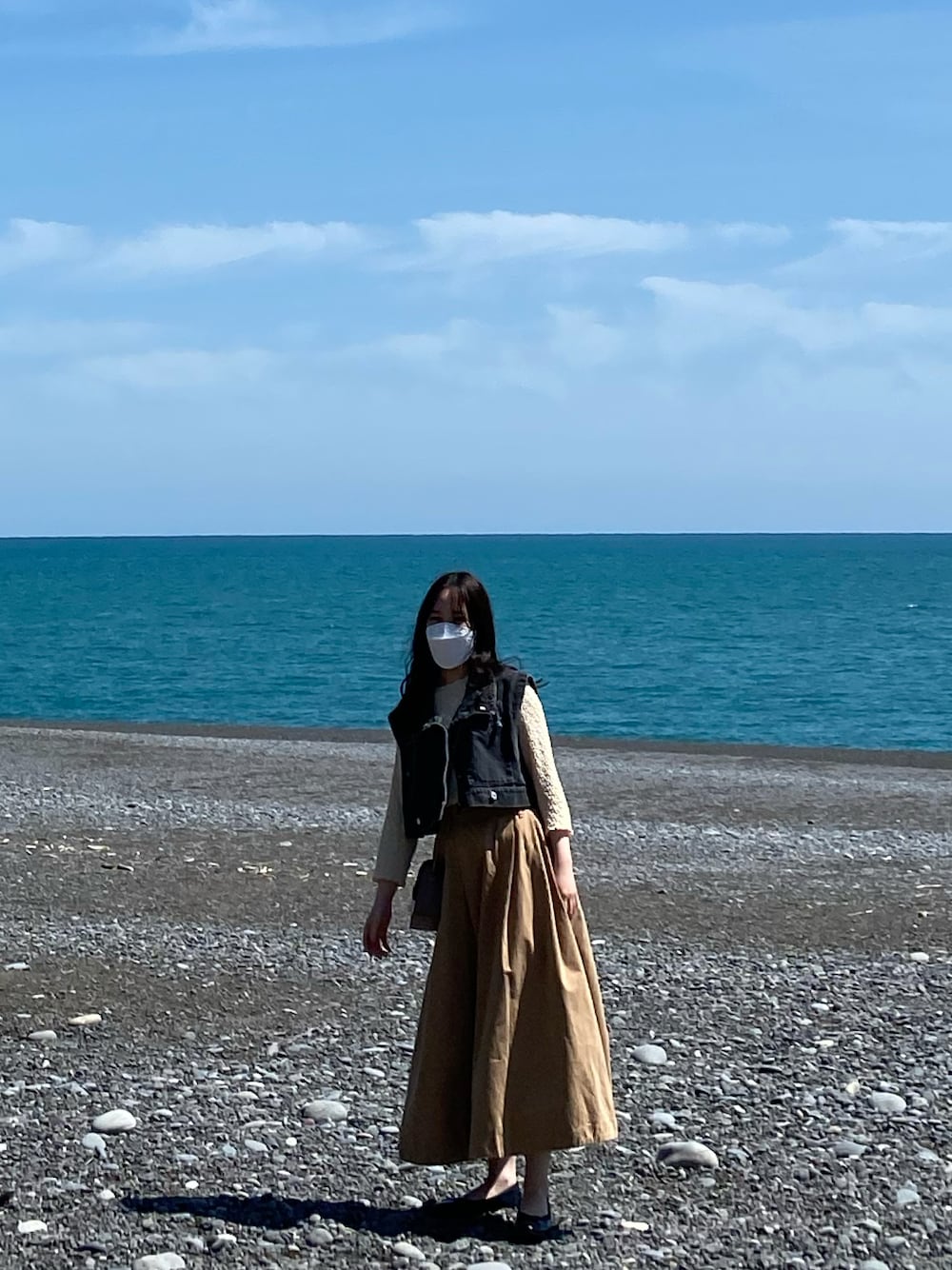 ブラック系のバレエシューズ、ベージュ系のスカート、ブラック系のデニムジャケットを着用したレディースの春コーディネートの1枚目の写真