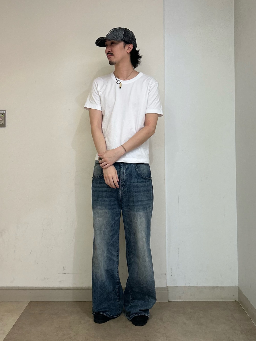 ブラック系のキャップを着用したメンズの夏コーディネートの1枚目の写真