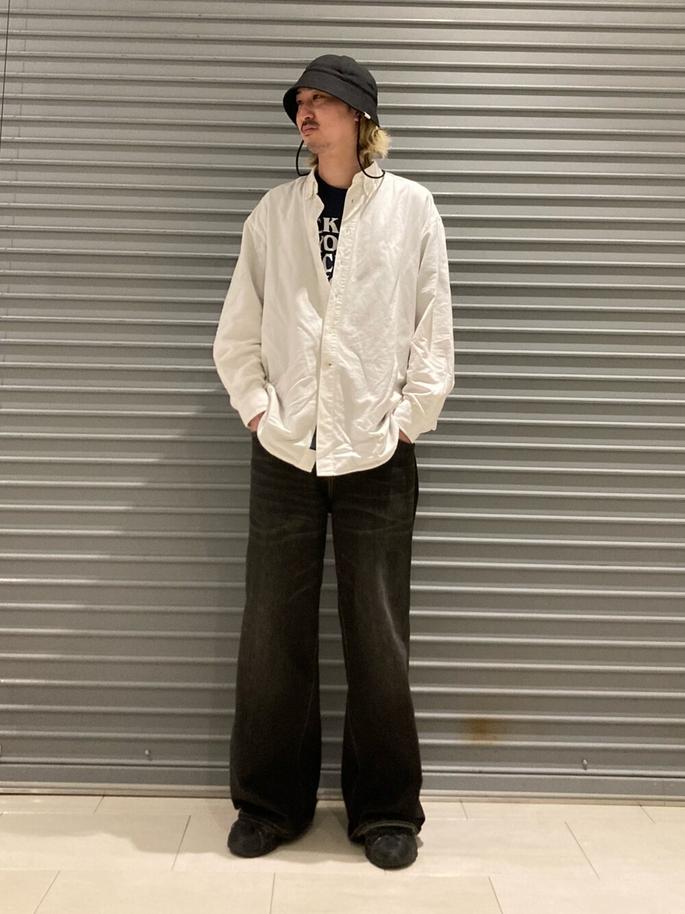 ブラック系のデニムパンツ、ブラック系のスニーカー、ブルー系のTシャツ/カットソーを着用したメンズの冬コーディネートの1枚目の写真