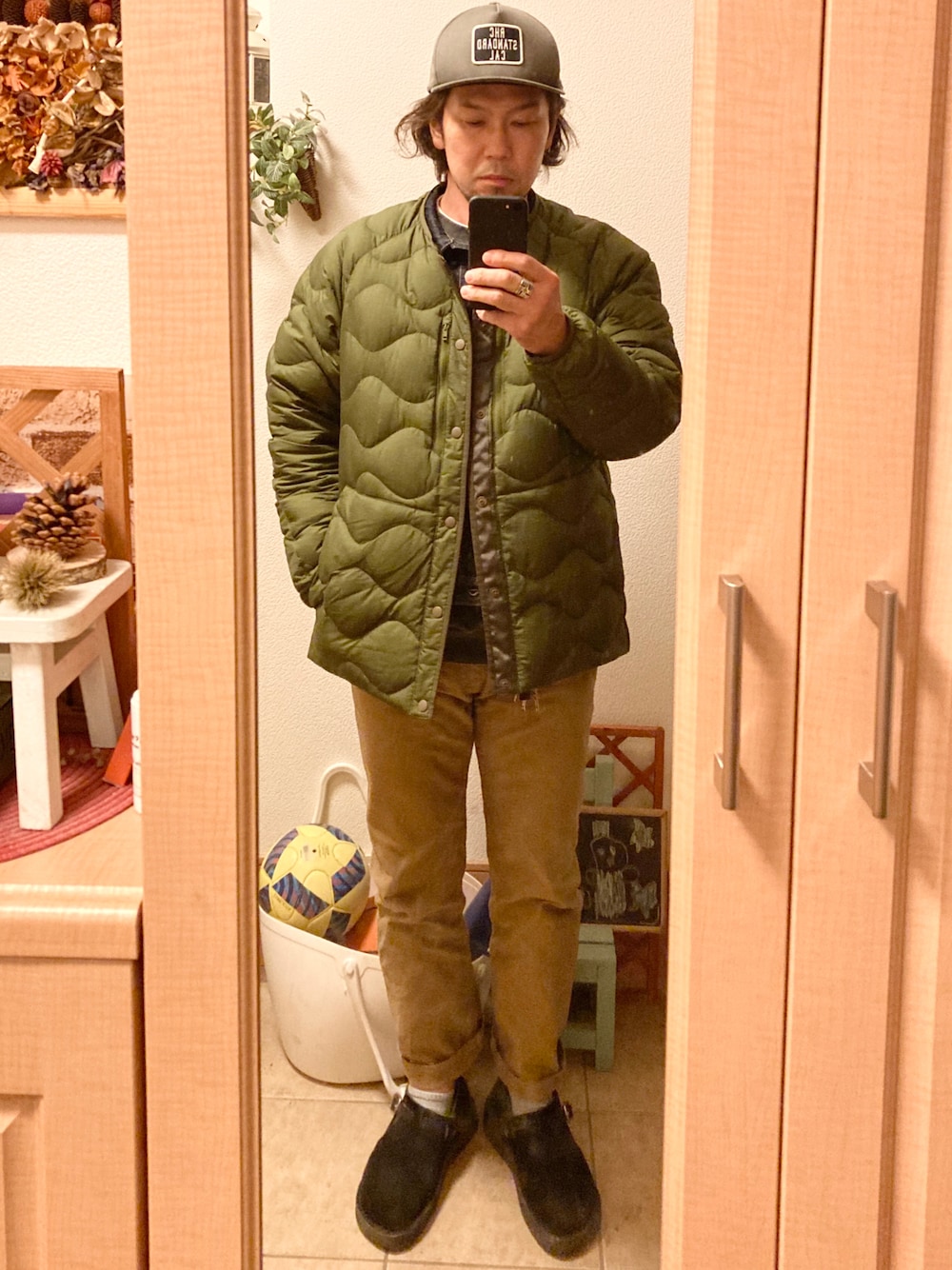 グリーン系のナイロンジャケット、ブルー系のデニムジャケット、ブラック系のスウェットを着用したメンズの冬コーディネートの1枚目の写真