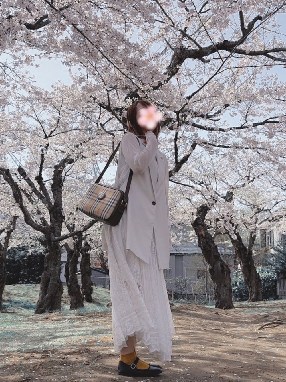 ブラウン系のショルダーバッグ、ホワイト系のスカート、ホワイト系のベストを着用したレディースの春コーディネートの1枚目の写真