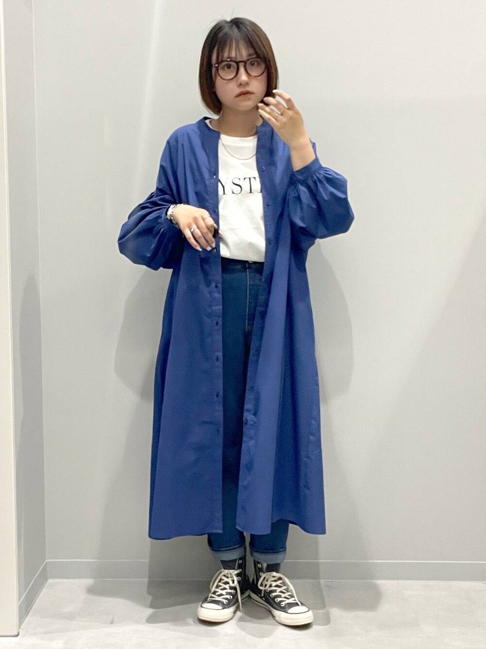 ホワイト系のTシャツ/カットソー、ブルー系のシャツワンピース、ブルー系のデニムパンツを着用したレディースの春コーディネートの1枚目の写真