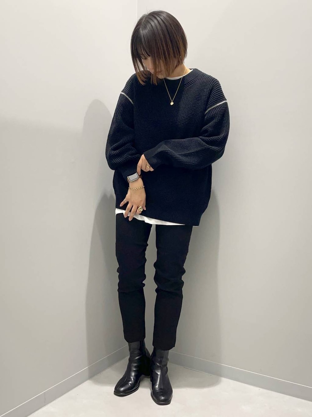 ブラック系のニット/セーター、ホワイト系のTシャツ/カットソー、ブラック系のその他パンツを着用したレディースの秋コーディネートの1枚目の写真