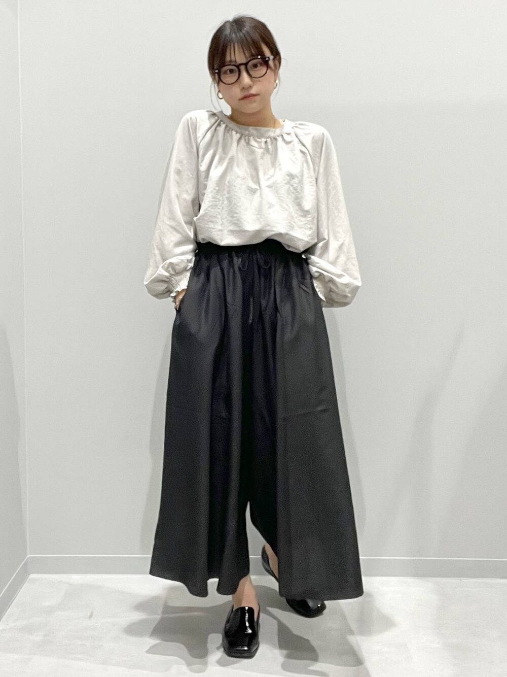 ブラック系のその他パンツ、グレー系のシャツ/ブラウスを着用したレディースの春コーディネートの1枚目の写真