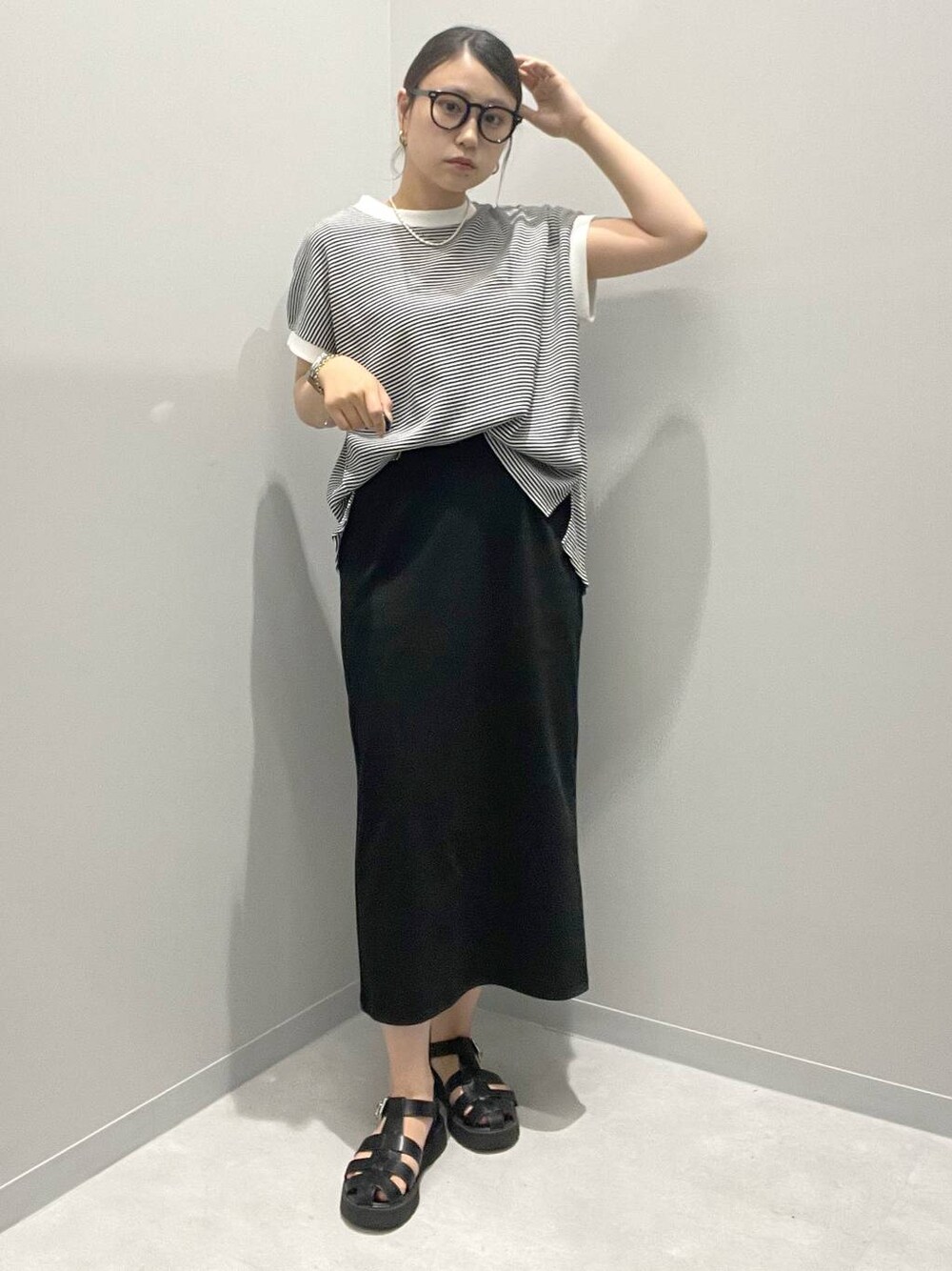 ブラック系のスカート、ホワイト系のTシャツ/カットソーを着用したレディースの夏コーディネートの1枚目の写真