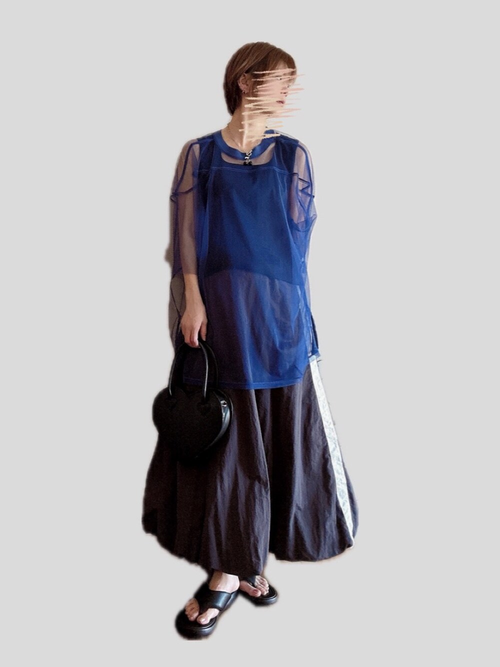 ブラック系のショルダーバッグ、グレー系のスカート、ブラック系のサンダルを着用したレディースの春コーディネートの1枚目の写真