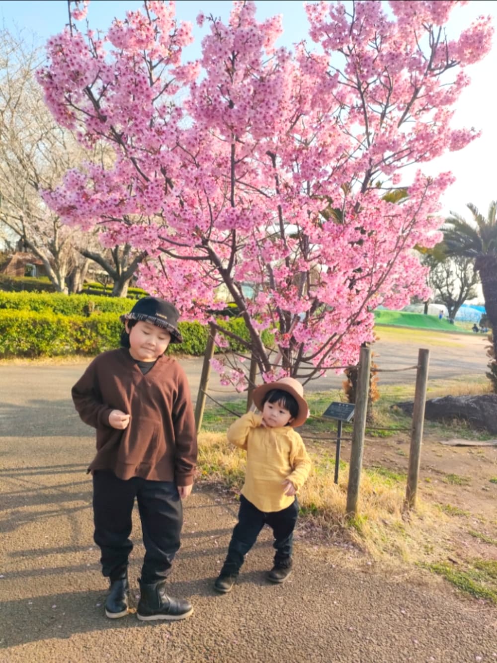 ブラウン系のパーカー、ブラック系のパンツ、ブラック系のブーツを着用したキッズの春コーディネートの1枚目の写真