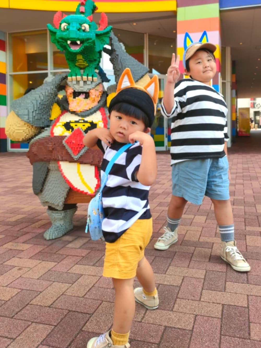 イエロー系のパンツ、ベージュ系のスニーカー、ブラック系のTシャツ/カットソーを着用したキッズの秋コーディネートの1枚目の写真