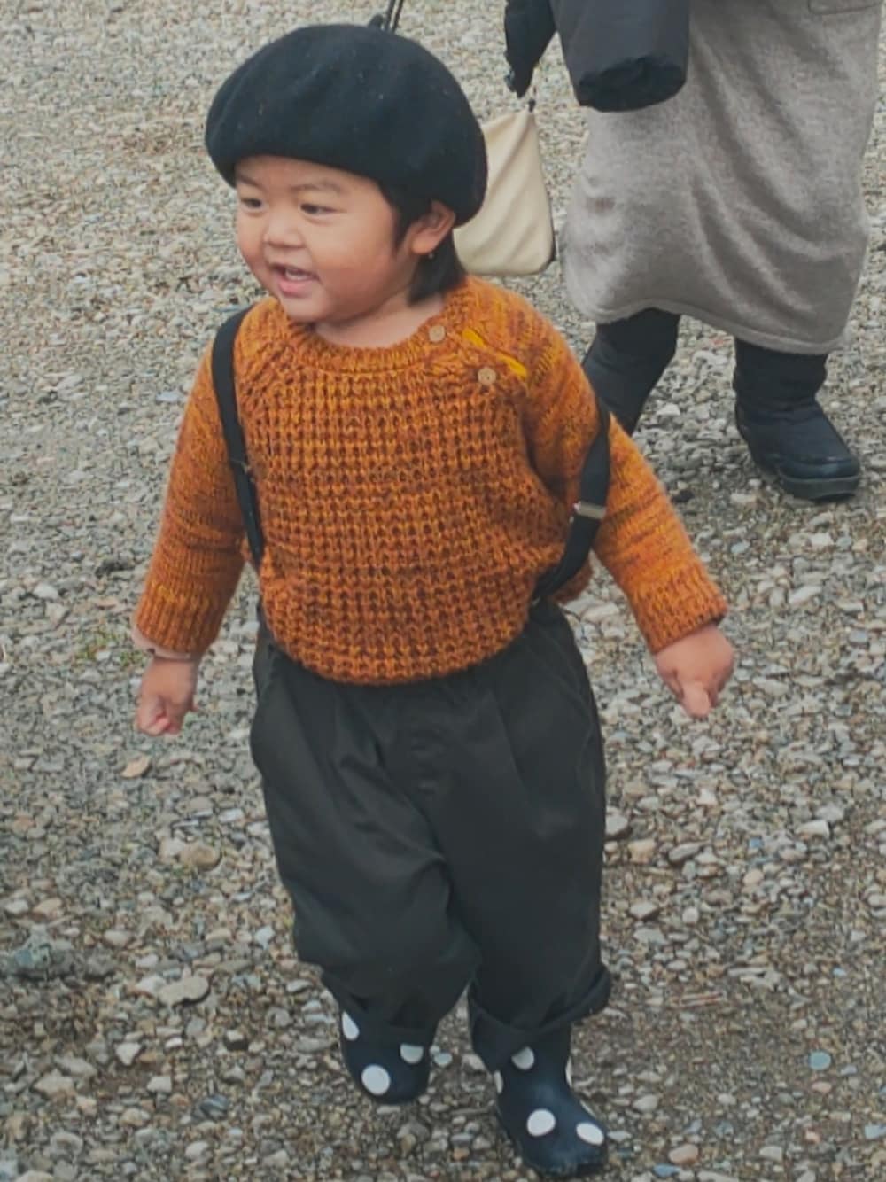 オレンジ系のニット/セーター、ブラック系のパンツ、ブラック系のレインシューズを着用したキッズの春コーディネートの1枚目の写真