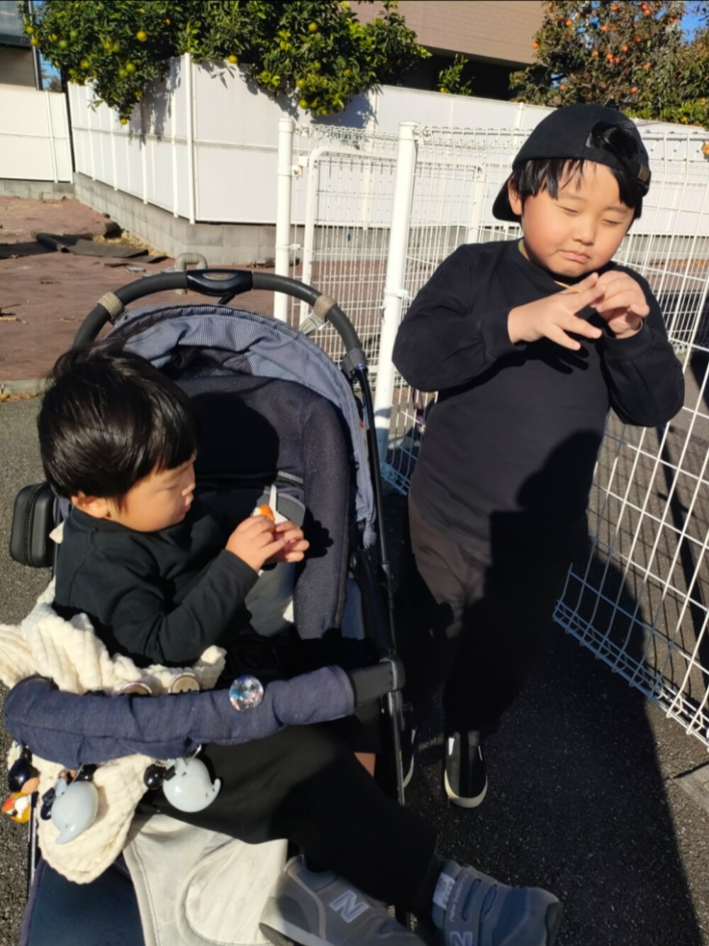ブラック系のTシャツ/カットソー、ブラック系のパンツ、ブラック系のスリッポンを着用したキッズの秋コーディネートの1枚目の写真