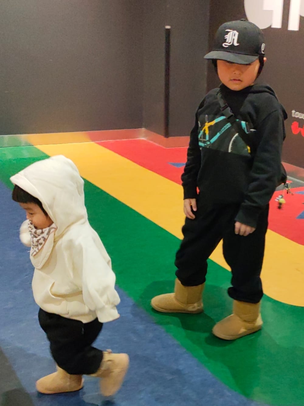 ブラック系のパンツ、ベージュ系のブーツ、ブラック系のパーカーを着用したキッズの冬コーディネートの1枚目の写真