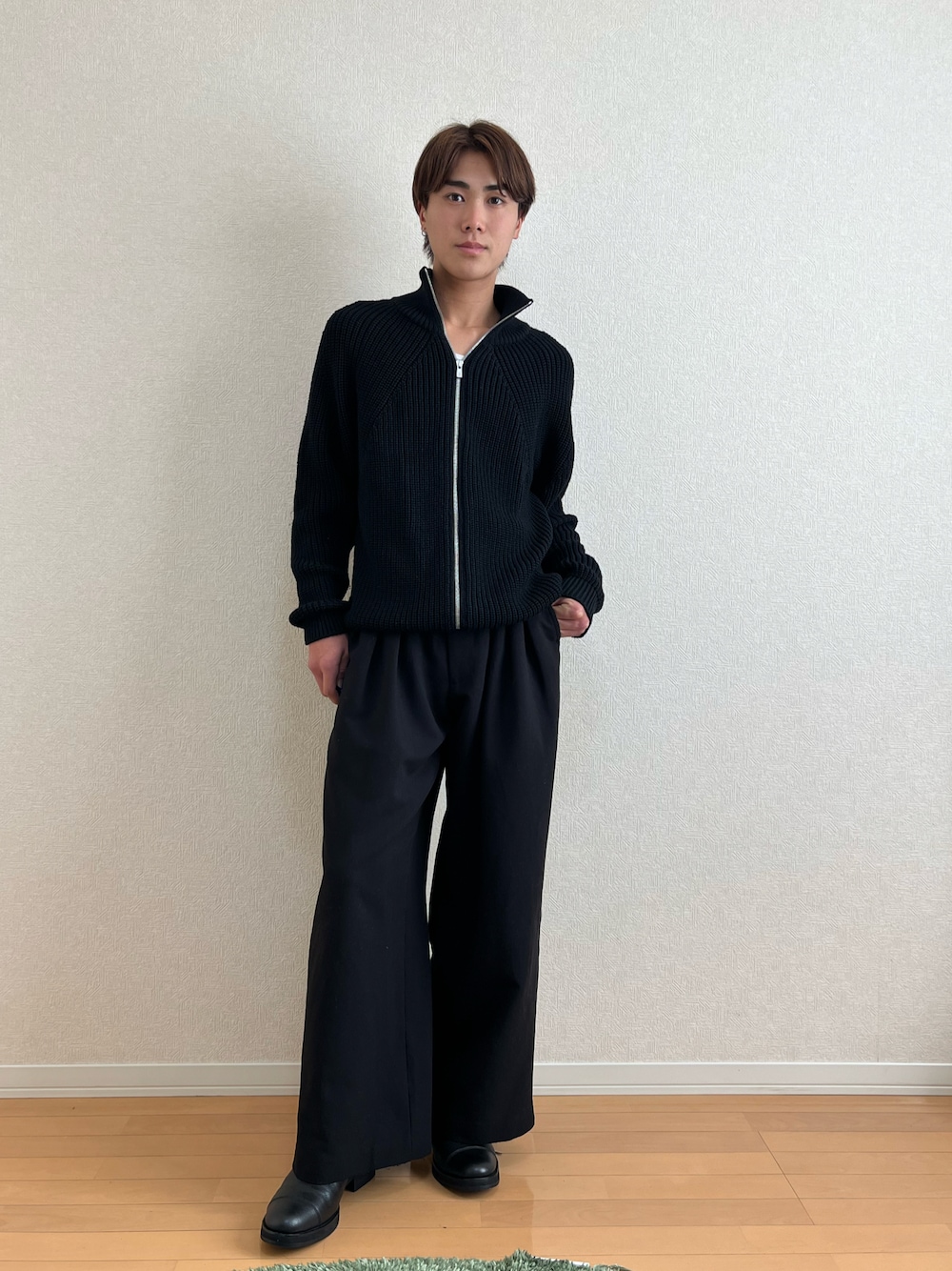 ブラック系のニット/セーター、ブラック系のブーツ、ブラック系のスラックスを着用したメンズの秋コーディネートの1枚目の写真