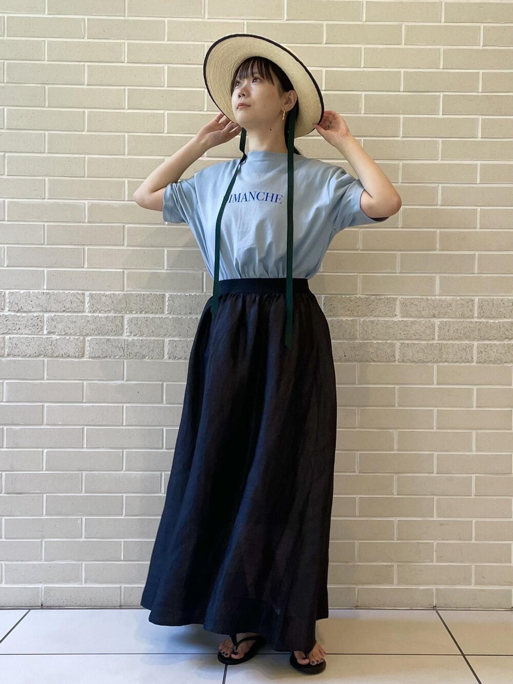 ベージュ系のサンダル、ブルー系のTシャツ/カットソー、ブラック系のスカートを着用したレディースの夏コーディネートの1枚目の写真