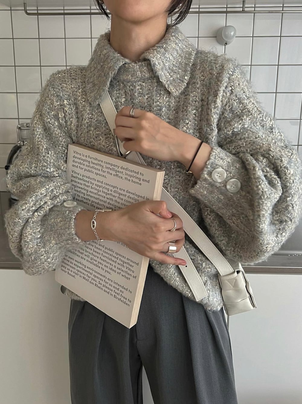 ブルー系のニット/セーター、ホワイト系のバッグを着用したレディースの秋コーディネートの1枚目の写真