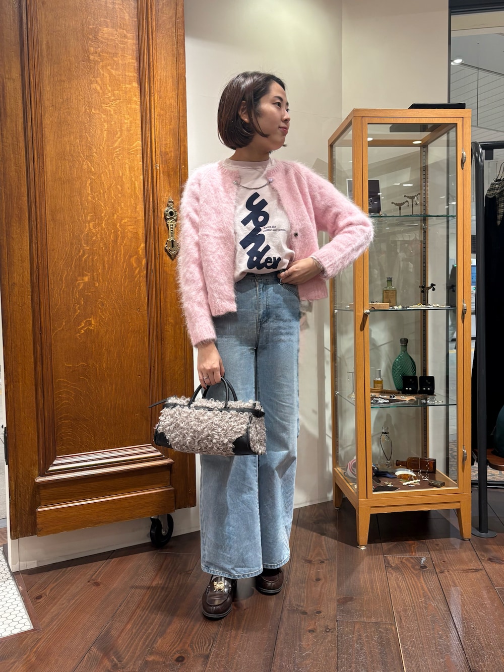 ブルー系のデニムパンツ、ピンク系のカーディガン/ボレロ、ピンク系のTシャツ/カットソーを着用したレディースの秋コーディネートの1枚目の写真