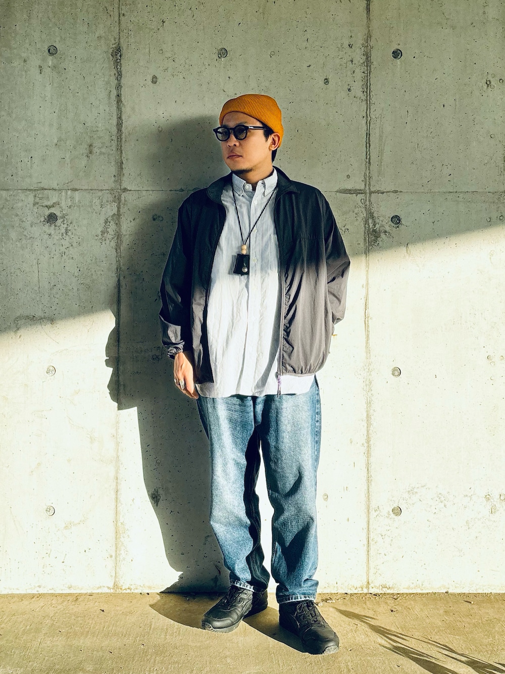 ブラック系のスニーカー、ブルー系のデニムパンツ、ブルー系のシャツ/ブラウスを着用したメンズの秋コーディネートの1枚目の写真