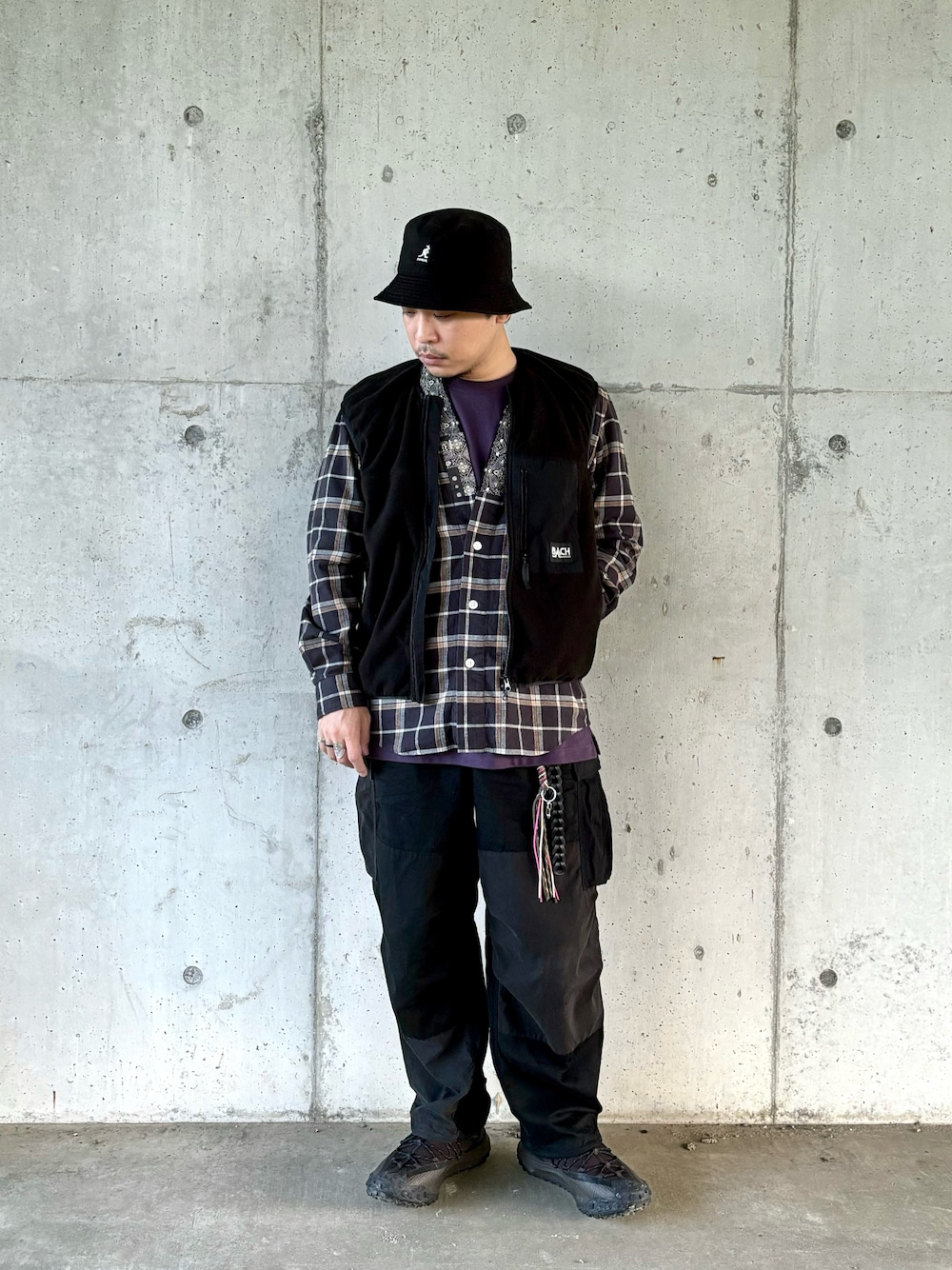 ブラック系のスニーカー、ブラック系のカーゴパンツ、ブラウン系のシャツ/ブラウスを着用したメンズの秋コーディネートの1枚目の写真