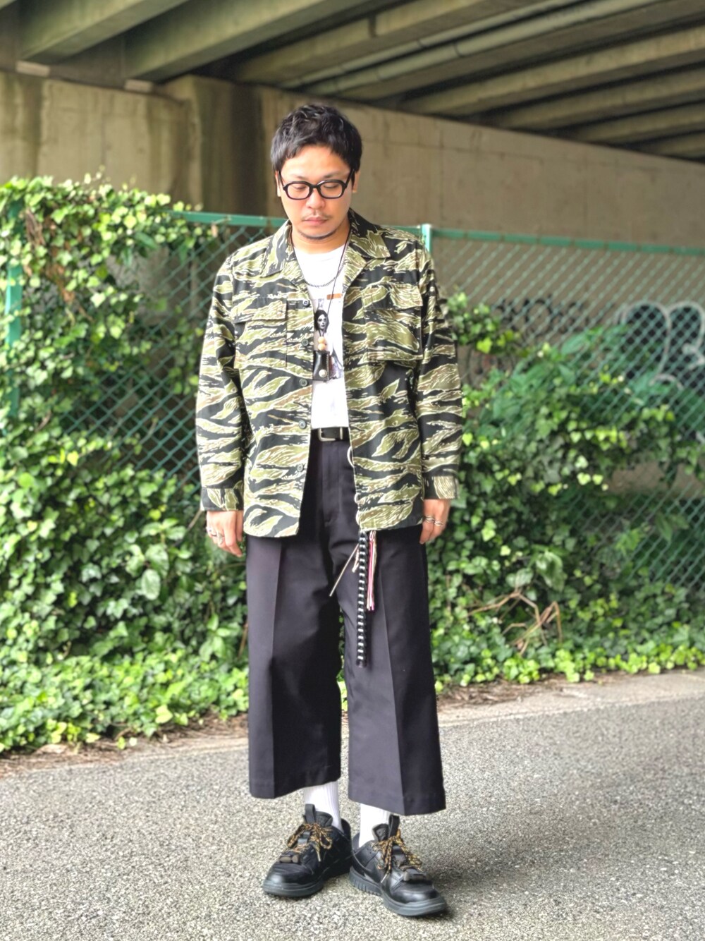 グリーン系のミリタリージャケット、ホワイト系のTシャツ/カットソー、ブラック系のその他パンツを着用したメンズの夏コーディネートの1枚目の写真