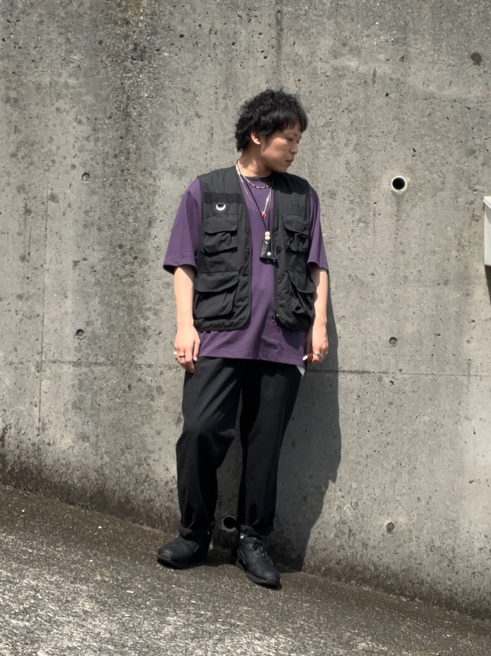 ブラック系のスニーカー、ブラック系のチノパンツ、ブラック系のベストを着用したメンズの夏コーディネートの1枚目の写真