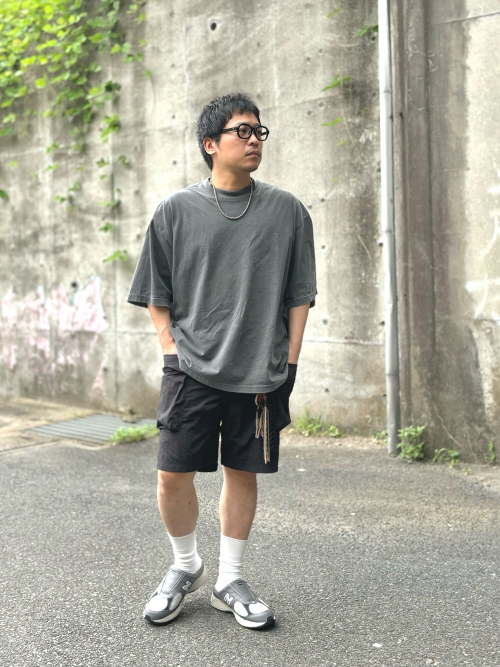 ブラック系のTシャツ/カットソー、ブラック系のカーゴパンツ、グレー系のスニーカーを着用したメンズの夏コーディネートの1枚目の写真