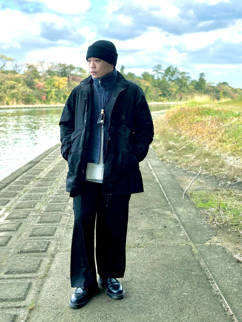 ブルー系のベスト、ブラック系のジャケット/アウター、グレー系のニット/セーターを着用したメンズの冬コーディネートの1枚目の写真