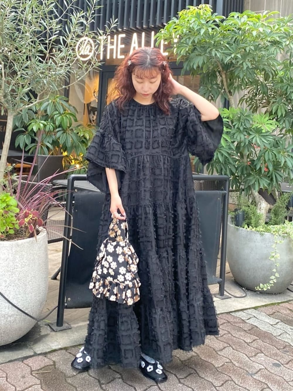 ブラック系のワンピース、ブラック系のパンプス、その他のハンドバッグを着用したレディースの秋コーディネートの1枚目の写真