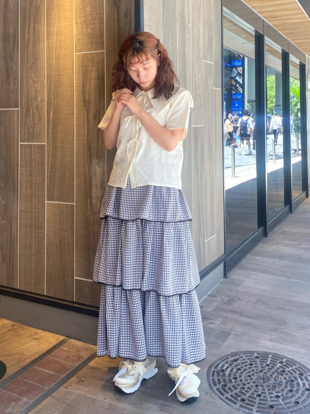 ホワイト系のスニーカー、ブラック系のスカート、ホワイト系のシャツ/ブラウスを着用したレディースの夏コーディネートの1枚目の写真