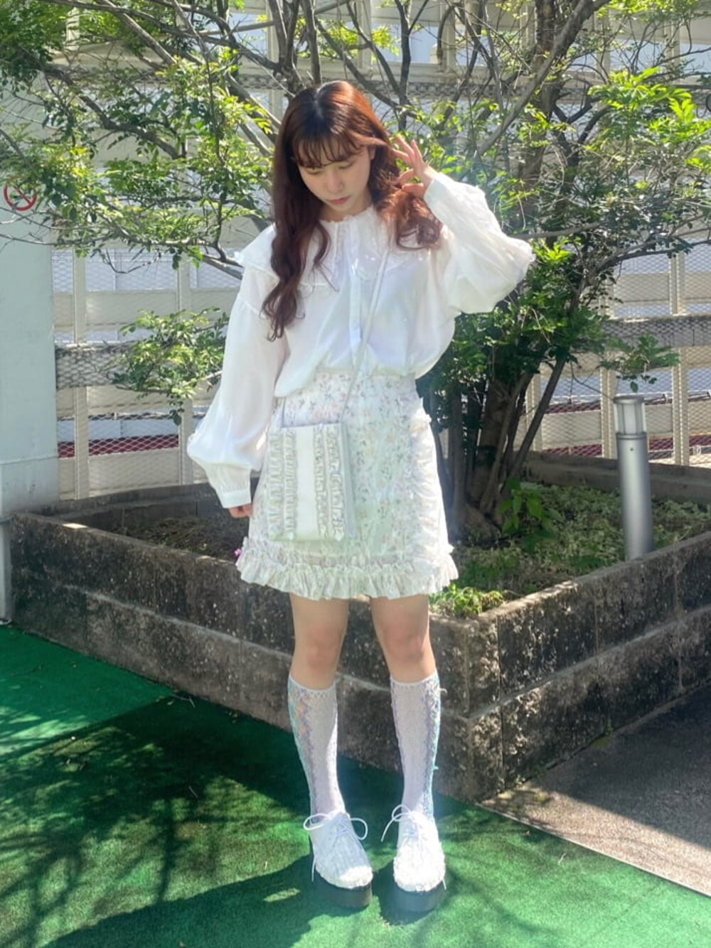 ホワイト系のショルダーバッグ、ホワイト系のシャツ/ブラウス、ピンク系のスカートを着用したレディースの春コーディネートの1枚目の写真