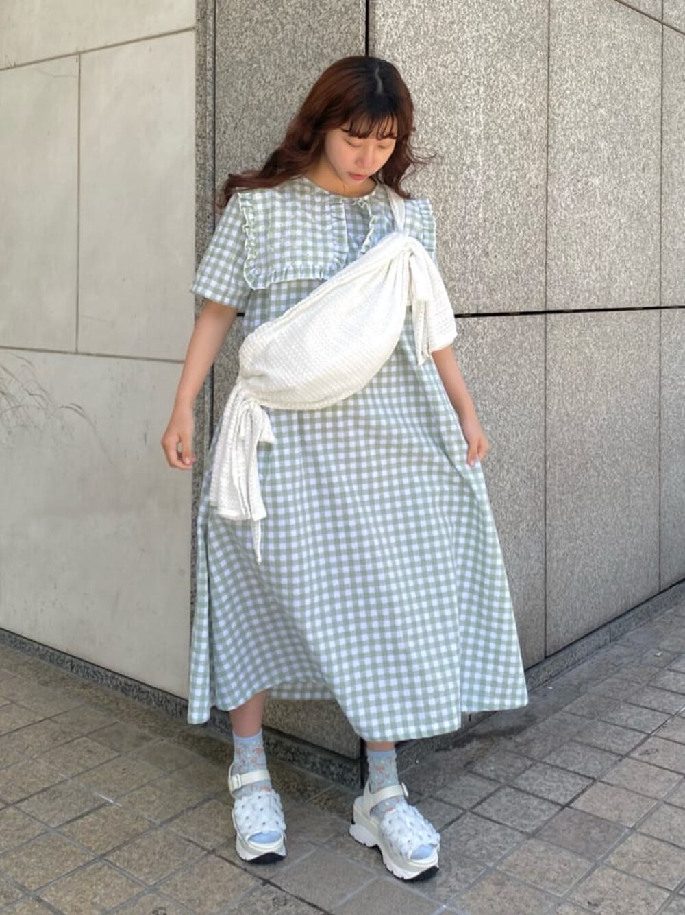 ホワイト系のサンダル、ホワイト系のショルダーバッグ、グリーン系のワンピースを着用したレディースの春コーディネートの1枚目の写真