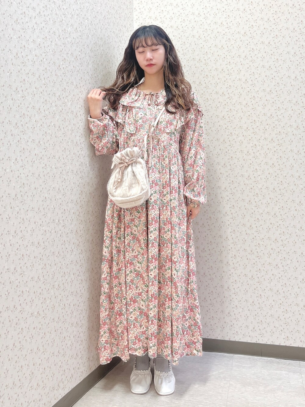 ピンク系のワンピース、ピンク系のショルダーバッグ、ホワイト系のパンプスを着用したレディースの春コーディネートの1枚目の写真