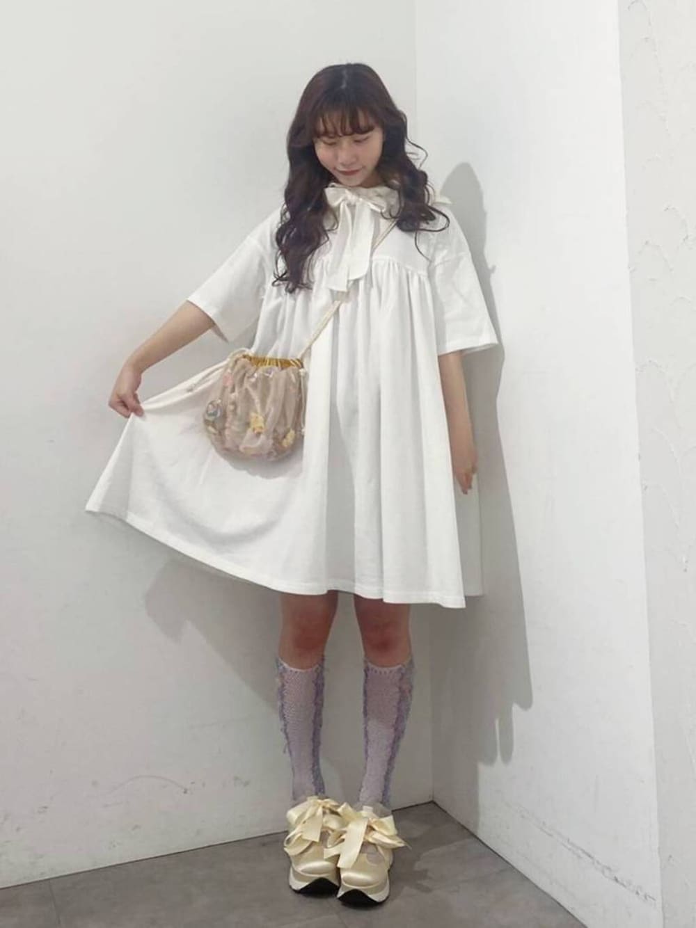 ホワイト系のスニーカー、ピンク系のショルダーバッグ、ホワイト系のワンピースを着用したレディースの春コーディネートの1枚目の写真