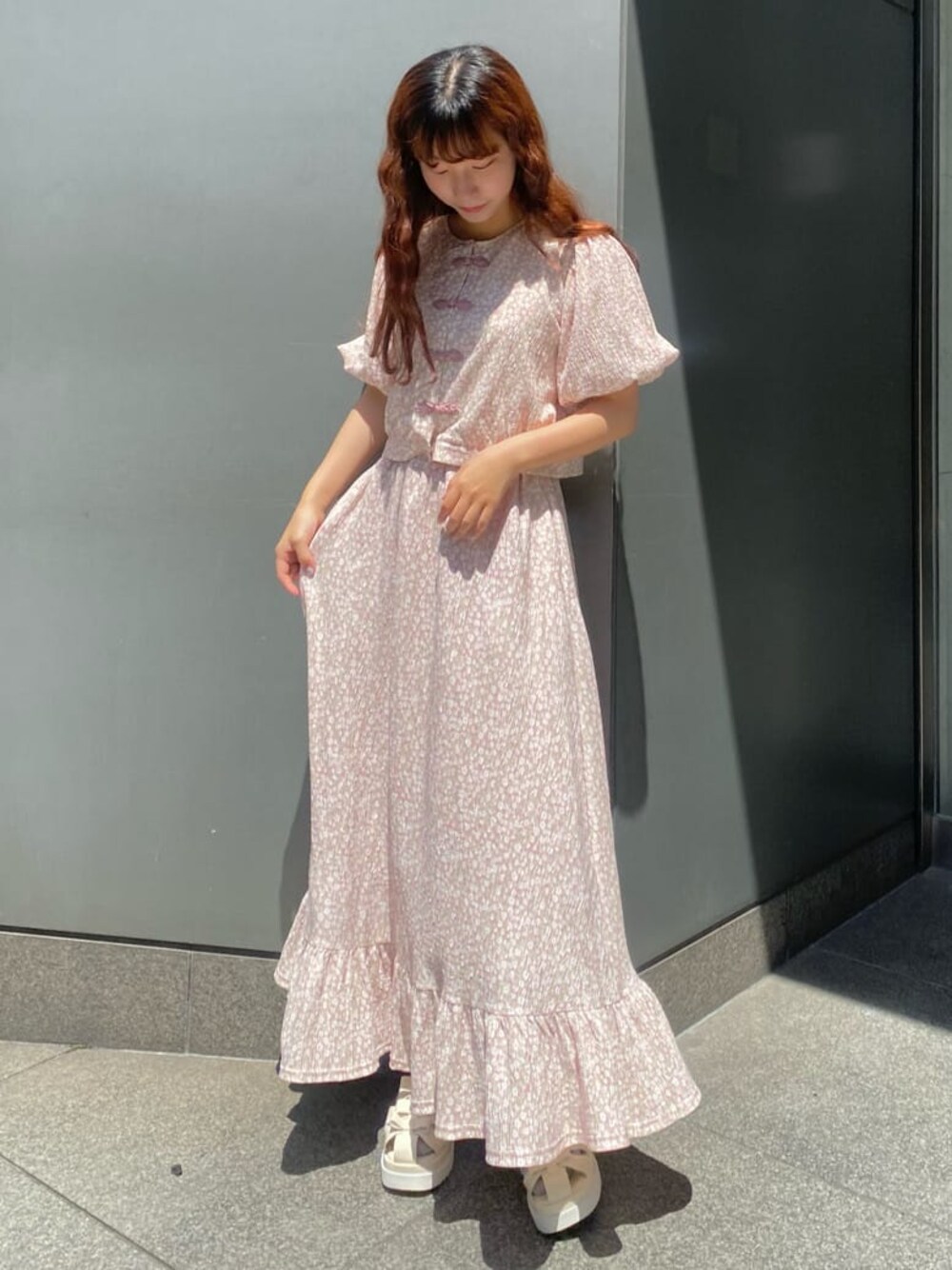 ピンク系のシャツ/ブラウス、ピンク系のスカート、ホワイト系のサンダルを着用したレディースの春コーディネートの1枚目の写真