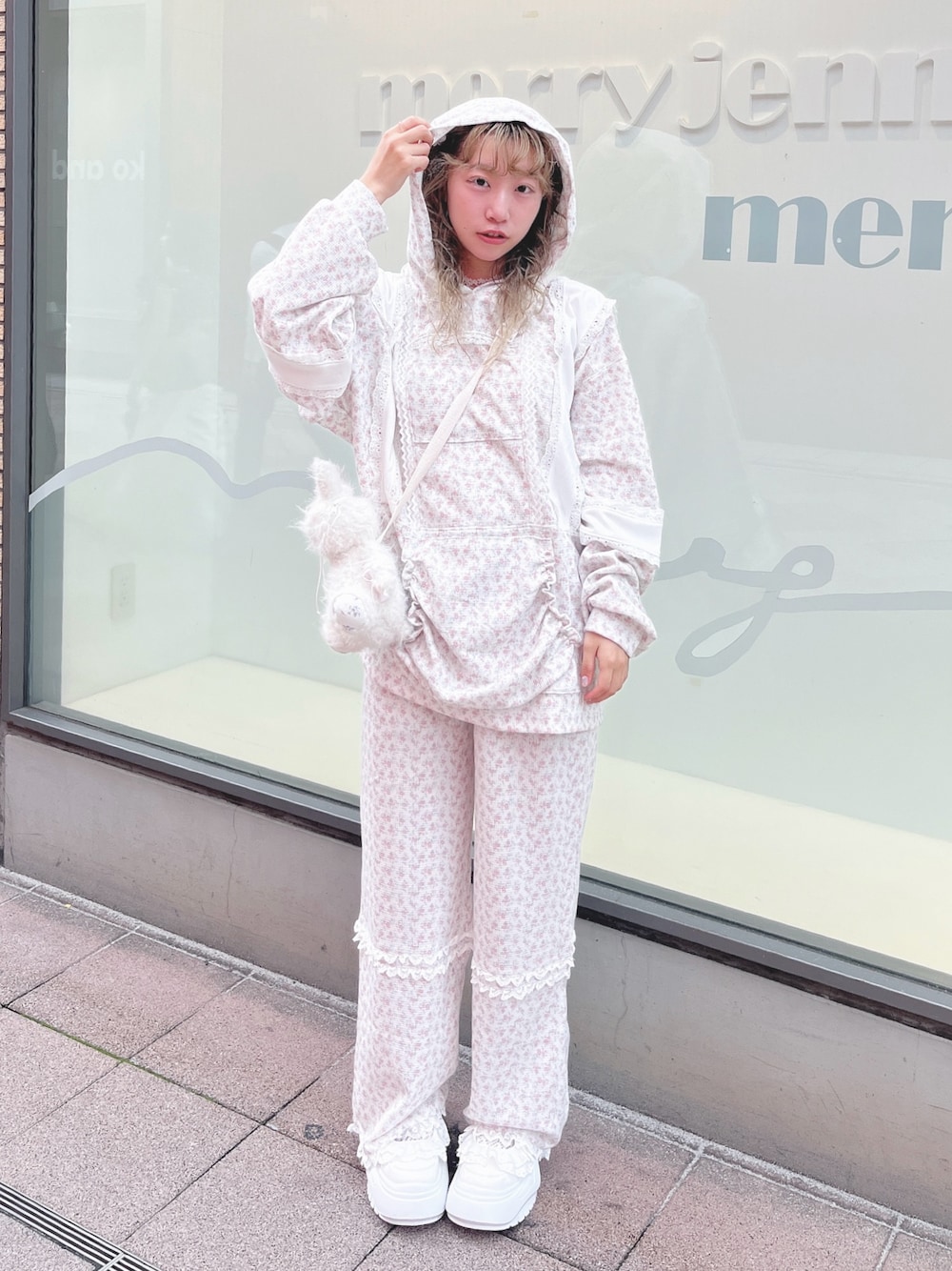 ピンク系のパーカー、ピンク系のカーゴパンツ、ホワイト系のショルダーバッグを着用したレディースの秋コーディネートの1枚目の写真
